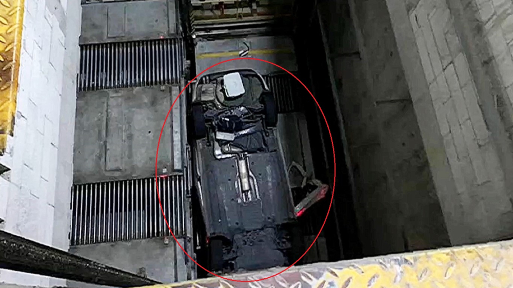 Chiếc ô tô nằm lật ngửa trong hố thang