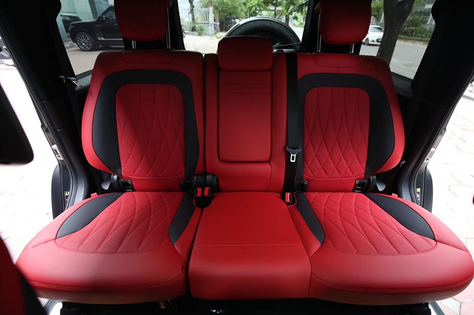 Hàng ghế sau của xe với 3 chỗ ngồi. Da ghế bọc màu đỏ và đen.