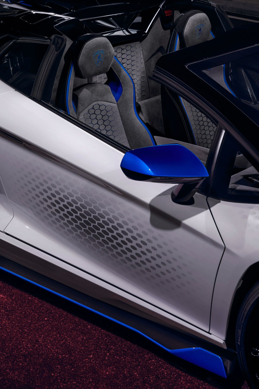 Khoang nội thất siêu xe Lamborghini Aventador SVJ Roadster Xago Edition được bọc da Alcantara màu tối với lưng ghế có thêm hoa văn hình lục giác cùng các điểm nhấn sọc màu xanh dương đầy tinh tế được tạo ra trong vòng 80 giờ.