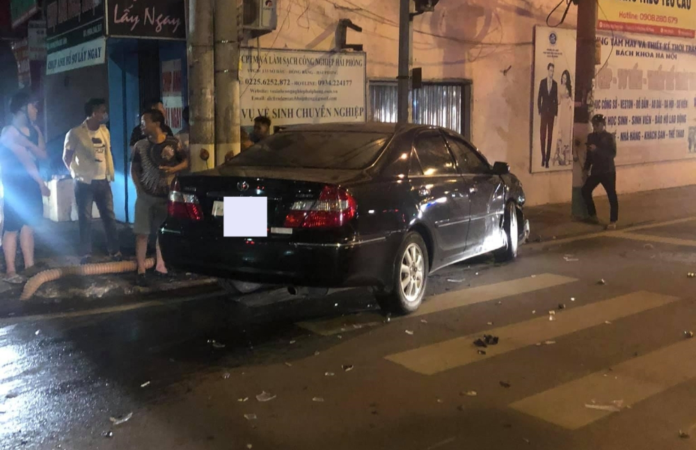 Chiếc xe Toyota Camry sau va chạm với xe taxi đã tông tiếp vào một trụ đèn bên đường Chiếc xe Toyota Camry sau va chạm với xe taxi đã tông tiếp vào một trụ đèn bên đường