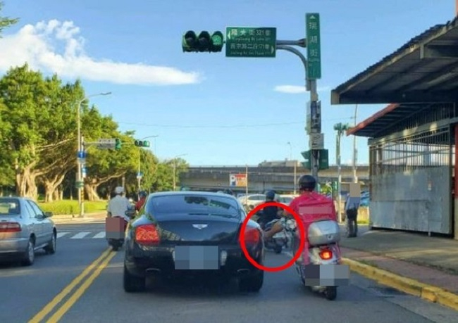 Người đàn ông giao hàng thản nhiên gác chân lên sườn chiếc xe sang Bentley Người đàn ông giao hàng thản nhiên gác chân lên sườn chiếc xe sang Bentley