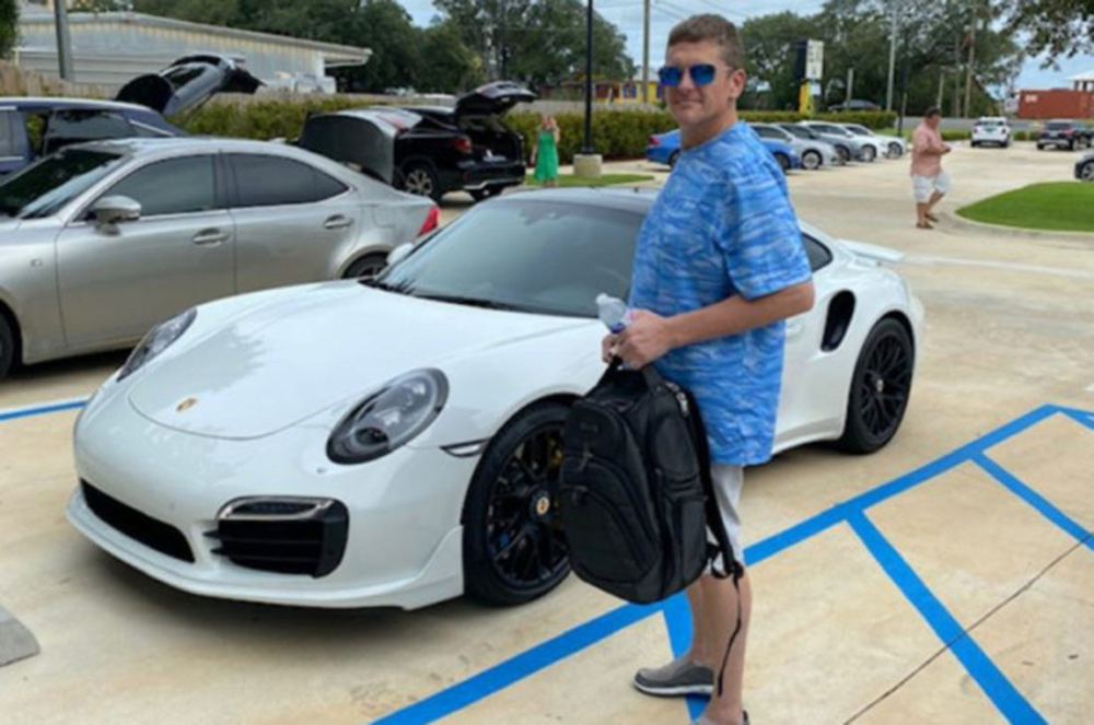&Ocirc;ng Kelly đứng b&ecirc;n chiếc Porsche 911 Turbo mua bằng tấm s&eacute;c giả