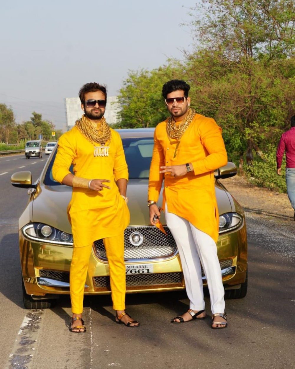 Cặp đôi Golden Guys tạo dáng bên chiếc Jaguar XF dán đề-can màu vàng crôm