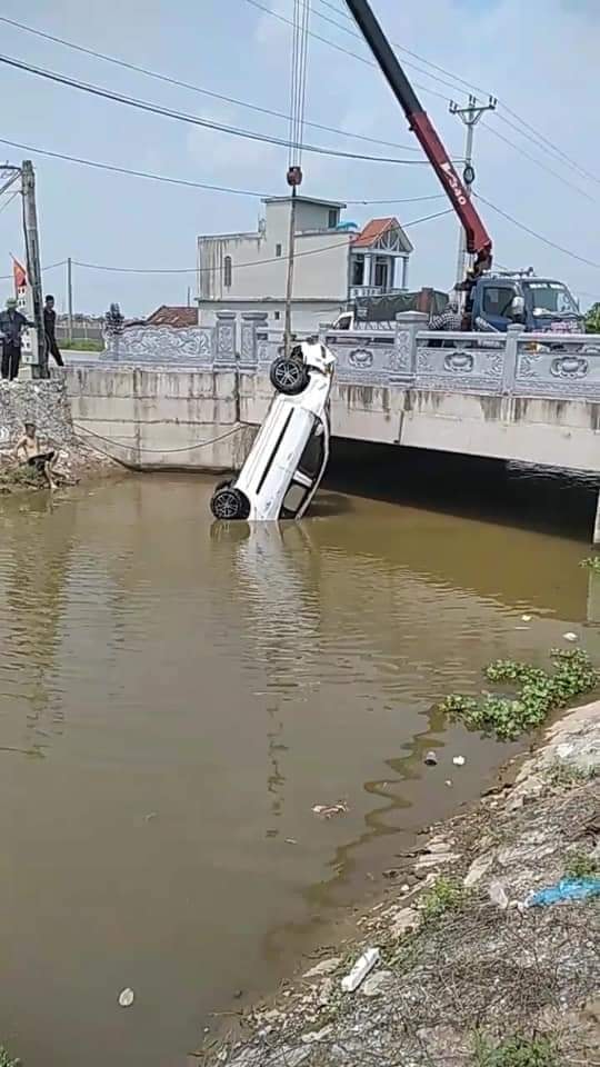 Chiếc ô tô màu trắng được trục vớt lên bờ