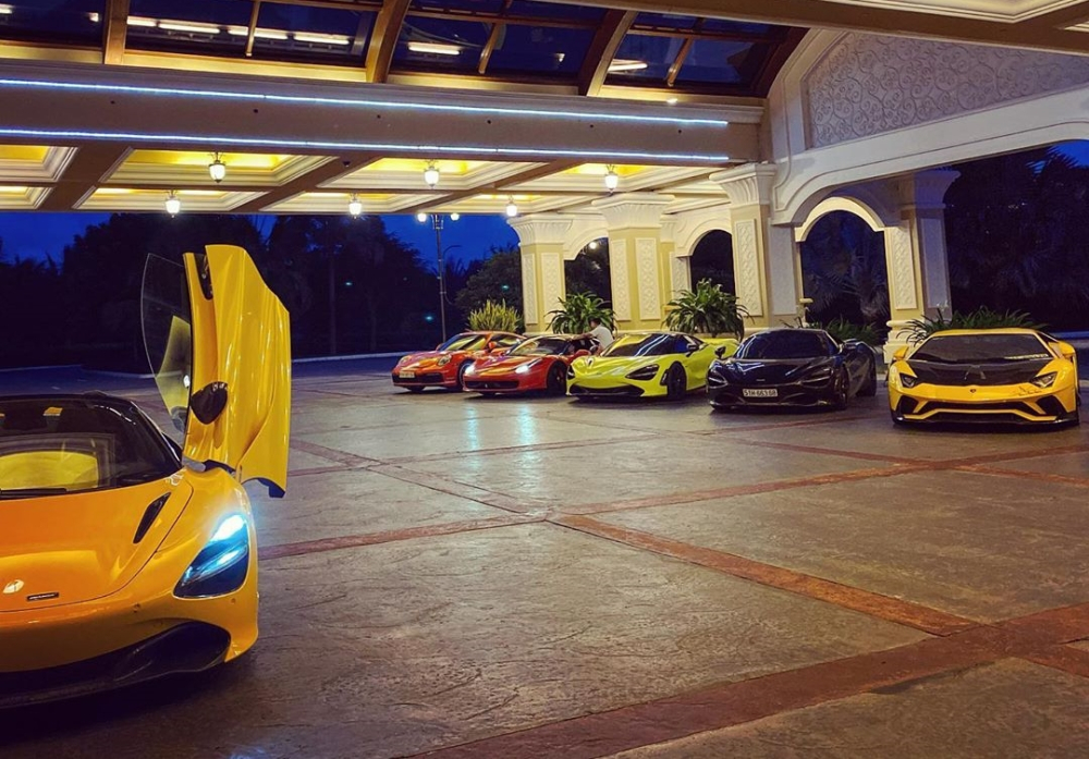 Siêu xe Lamborghini Aventador S đỗ cùng dàn siêu xe đẹp mắt của nhà giàu Việt bao gồm McLaren 720S Spider màu đen, McLaren 720S màu trắng dán xanh neon, Ferrari 458 Italia màu đỏ và cuối cùng là chiếc McLaren 720S Spider màu vàng đang tung cánh
