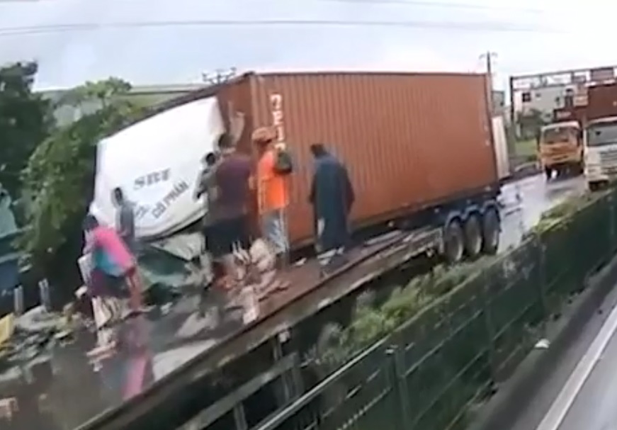 Người dân hỗ trợ kéo tài xế xe container ra ngoài