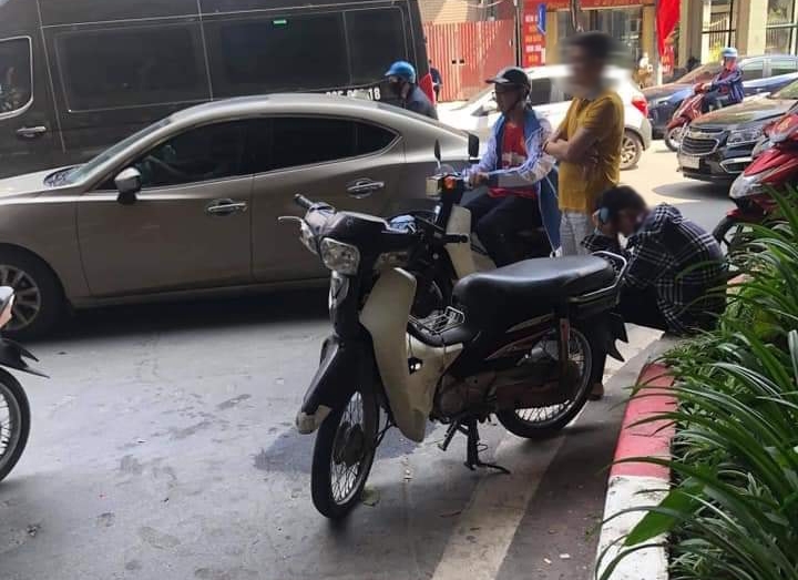 Nam thanh ni&ecirc;n ngồi b&ecirc;n đường v&agrave; &ocirc;m mặt, chiếc xe m&aacute;y cũng bị hư hỏng