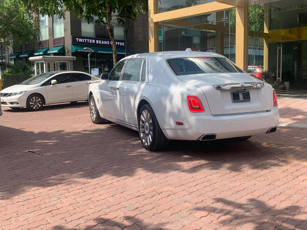 Về chiếc xe siêu sang Rolls-Royce Phantom Tranquillity thứ 2 về Việt Nam, xe mang ngoại thất màu trắng đi kèm nắp capô màu tối, chưa hết, biểu tượng Spirit of Ecstasy của xe bằng chất liệu titan màu tối và dưới chân logo này là tên phiên bản xe in dập nổi.