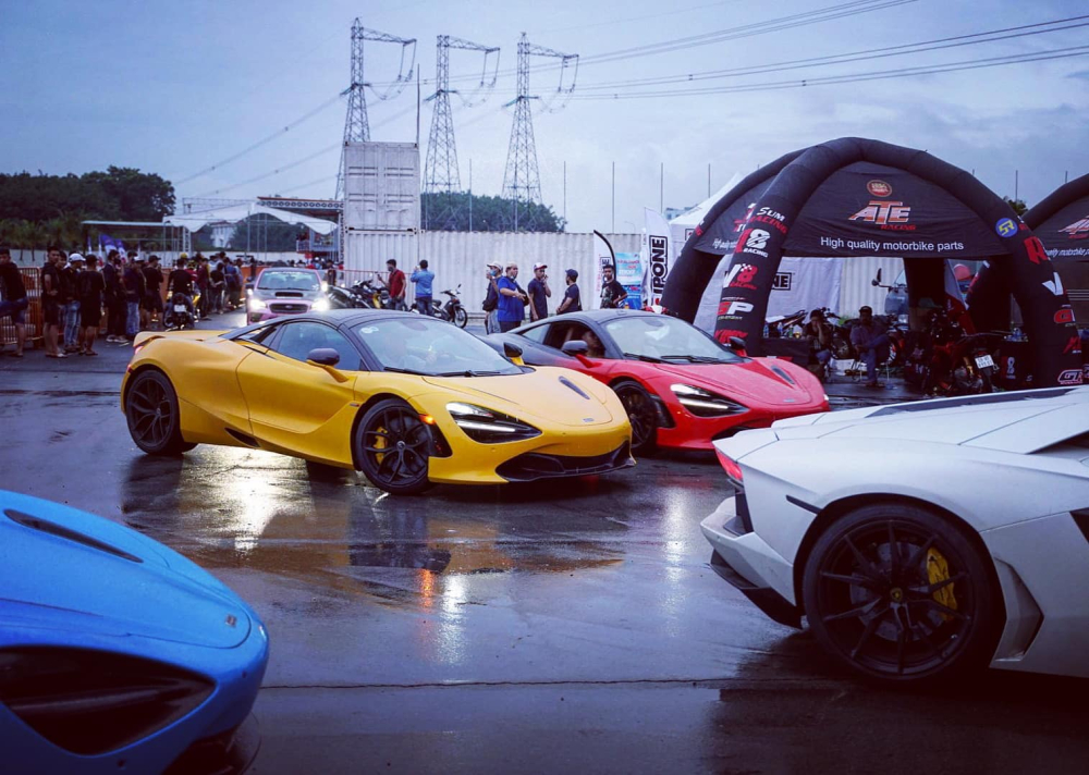 McLaren 720S Spider màu vàng và McLaren 720S màu đỏ-đen đỗ cạnh nhau, ngoài ra còn có McLaren 720S Spider màu xanh-đen và Lamborghini Aventador LP700-4 màu trắng
