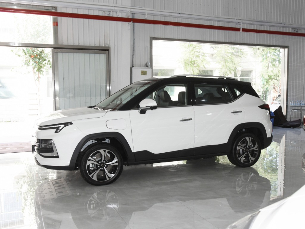Nhìn bên sườn, ta thấy xe có bộ la-zăng 5 chấu kiểu cánh quạt quay, các cột và nóc xe mang màu đen tương phản thân vỏ trắng