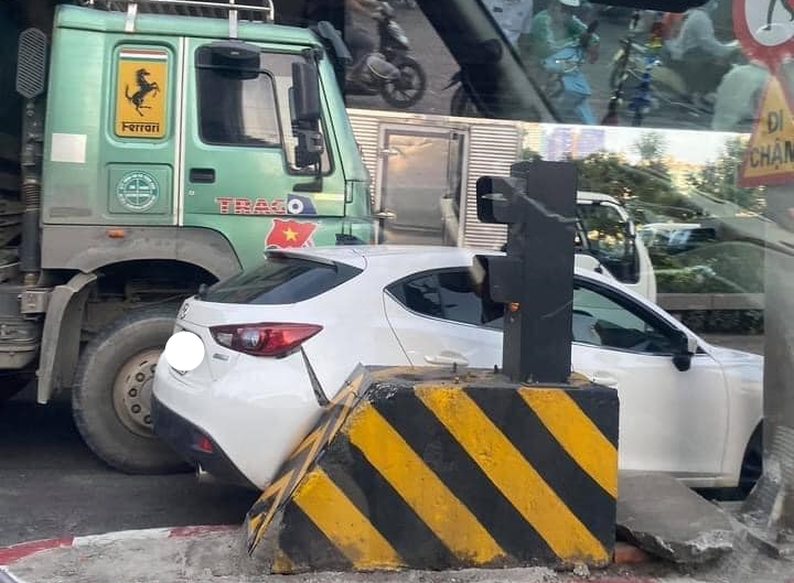 Chiếc xe Mazda 3 bị xe tải ép dính vào trụ bê tông của đèn tín hiệu giao thông