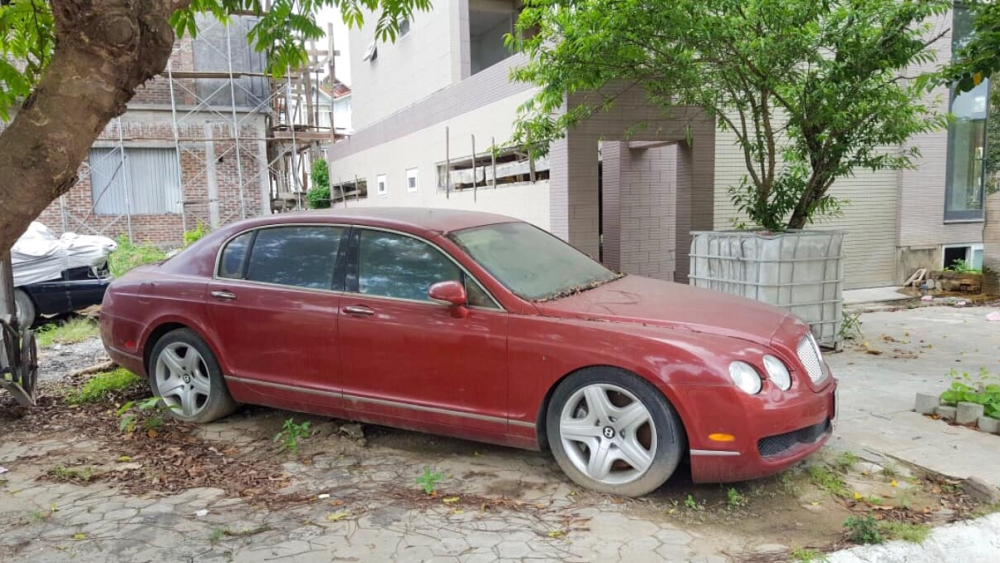 Đây là hình chiếc xe siêu sang Bentley Continental Flying Spur nhiều năm làm bạn với bụi dưới gốc cây tại Hải Phòng