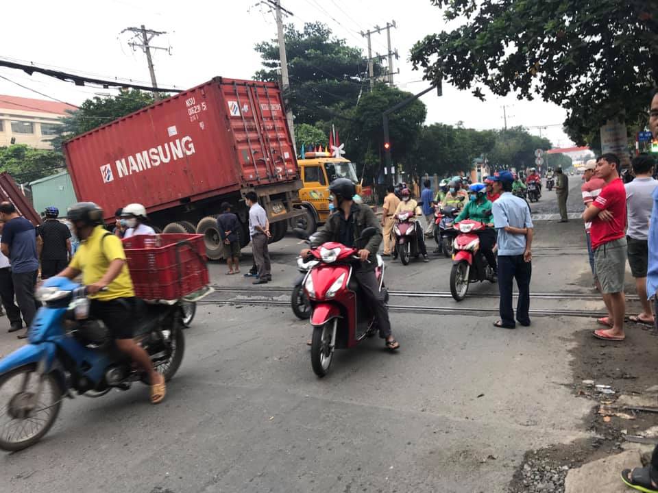 Lực lượng chức năng đang cẩu xe container cùng thùng container và rơ-móoc ra khỏi đường ray