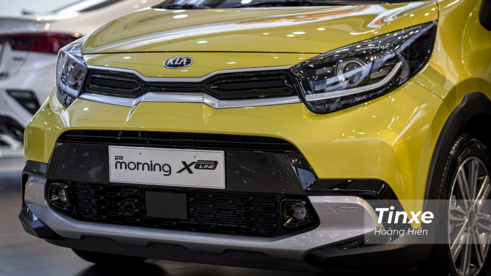 KIA Morning X-Line sở hữu phần đầu xe có phần góc cạnh hơn với lưới tản nhiệt mũi hổ được làm hẹp lại và cản trước góc cạnh nhô ra tạo cảm giác thể thao và cá tính cho chiếc xe này ở phần đầu xe.