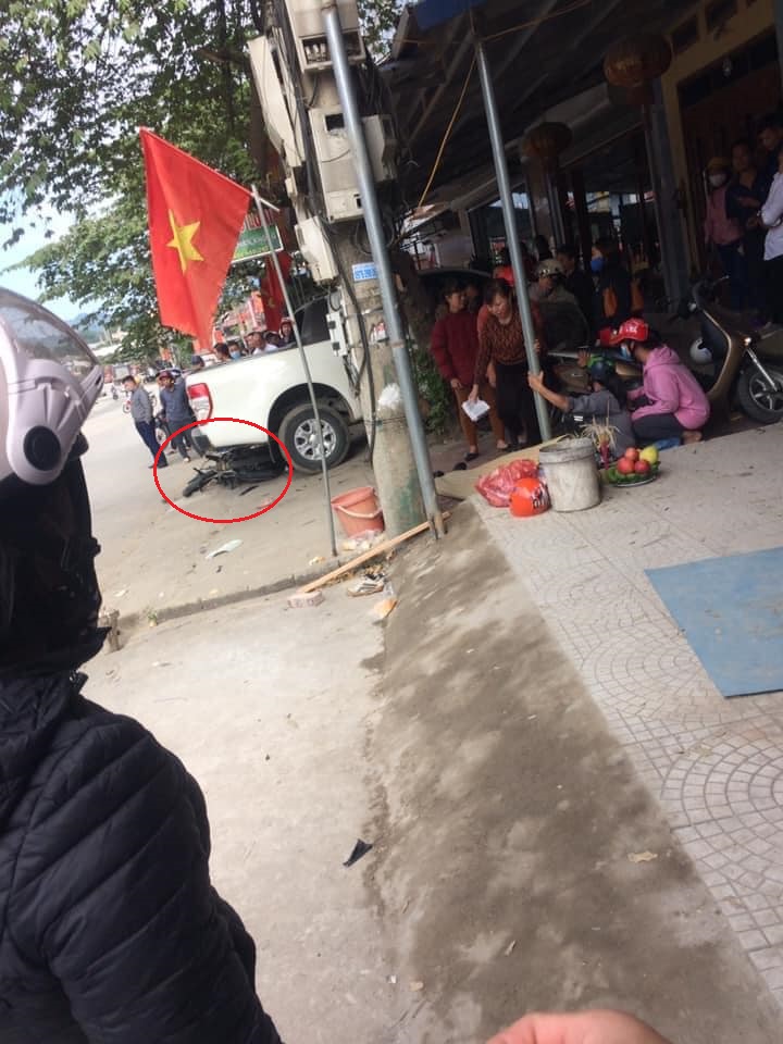 Chiếc xe máy nằm dưới gầm của chiếc xe bán tải đang đỗ trên vỉa hè