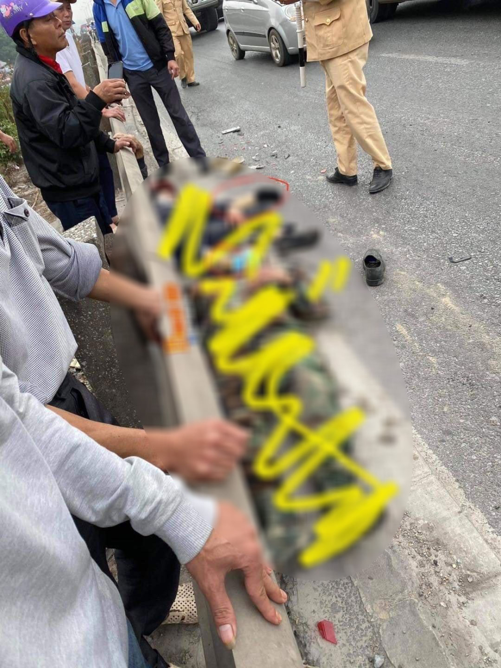 2 người đi xe máy nằm bên lề đường, sát với dải ta-luy 2 người đi xe máy nằm bên lề đường, sát với dải ta-luy