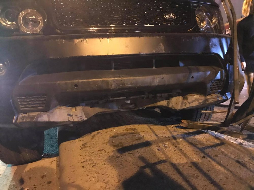 Cản va trước của xe Range Rover hư hỏng nặng sau khi lao lên dải phân cách và tông vào hàng rào sắt ở đây