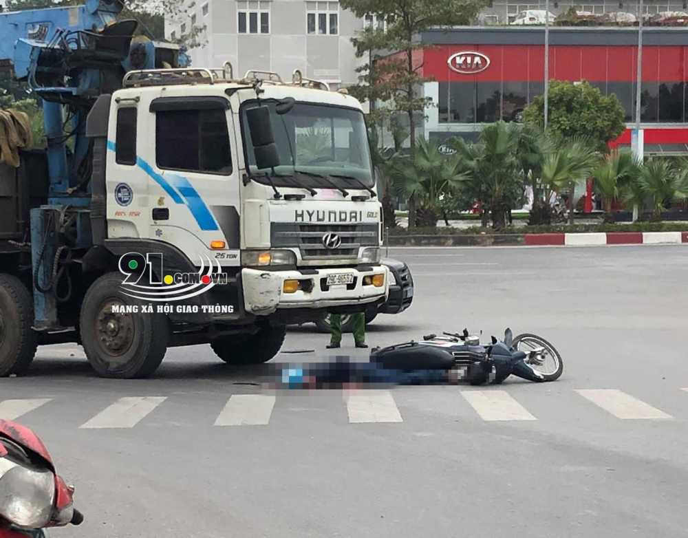 Chiếc xe m&aacute;y v&agrave; thi thể nạn nh&acirc;n nằm trước đầu &ocirc; t&ocirc; tải cẩu