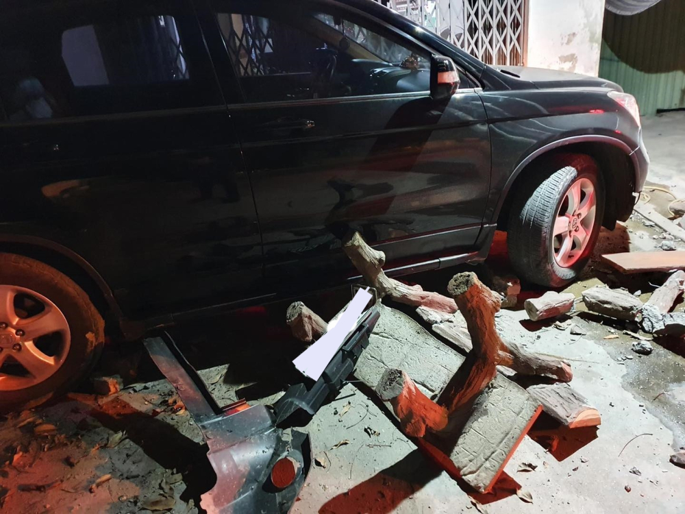 Một số vật dụng của nhà dân hư hỏng nằm cạnh cản va trước của xe Honda CR-V bung ra khỏi xe sau vụ tai nạn này