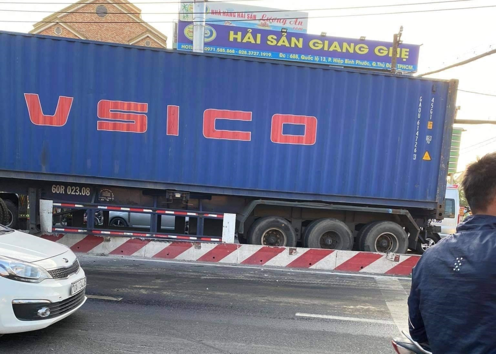 Phần rơ-mooc xe container nằm chắn một làn đường trên Quốc lộ 13 Phần rơ-mooc xe container nằm chắn một làn đường trên Quốc lộ 13