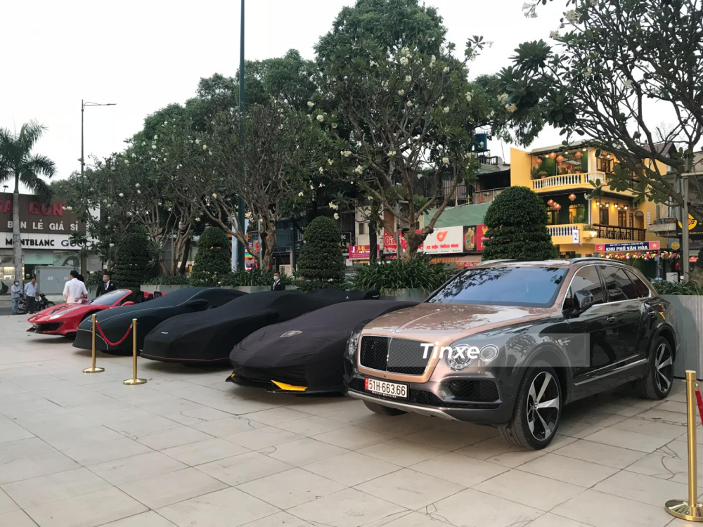 Bộ 3 Lamborghini Aventador S LP740-4, McLaren Senna hay Aston Martin V8 Vantage được vận chuyển đến địa điểm tập kết bằng xe chuy&ecirc;n dụng v&agrave; được tr&ugrave;m bạt. Đỗ ngo&agrave;i 2 ph&iacute;a đầu l&agrave; Bentley Bentayga V8 c&ugrave;ng Ferrari 488 Pista Spider độc nhất Việt Nam