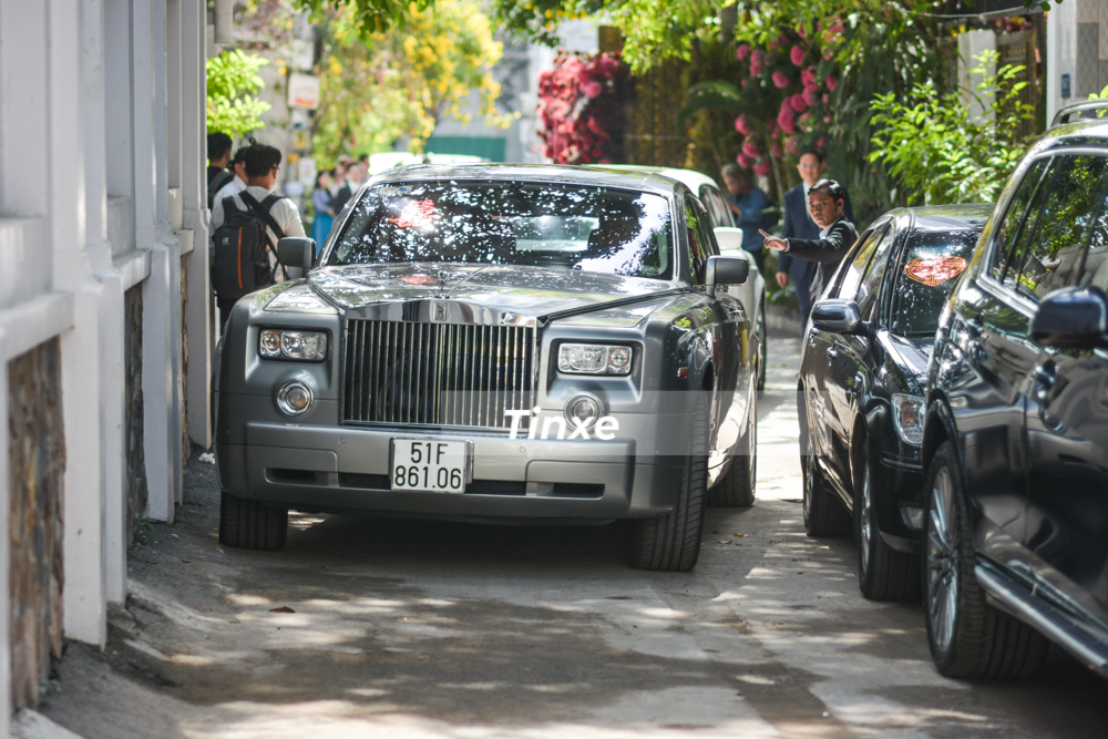 Rolls-Royce Phantom m&agrave;u bạc được t&agrave;i xế l&aacute;ch qua một chiếc xe Toyota Camry đời cũ v&agrave; BMW X7 để ra đường lớn.