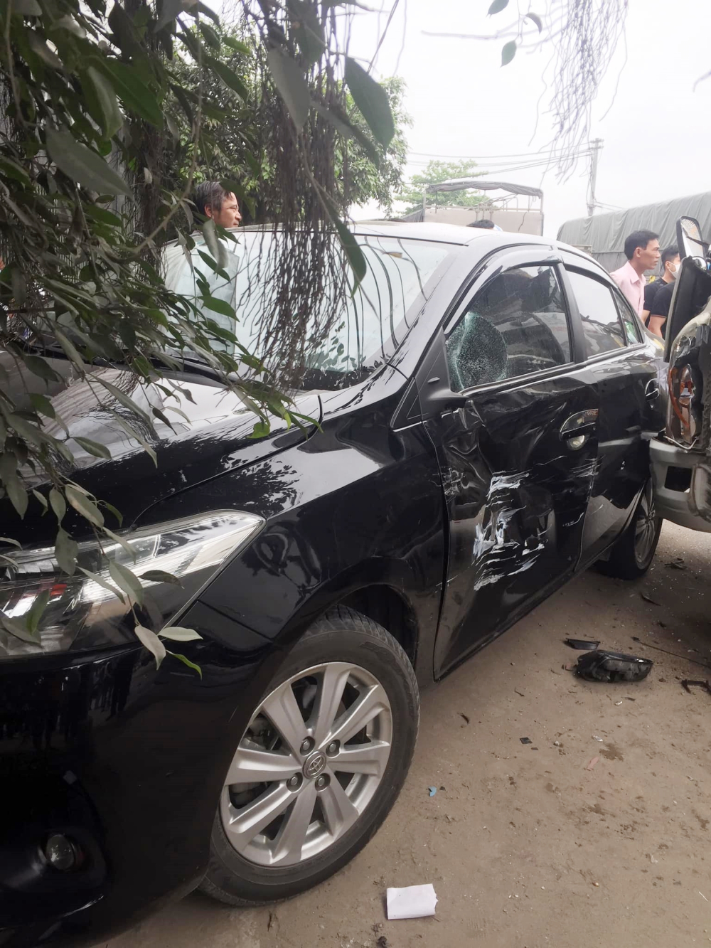 Chiếc xe Toyota Vios móp và xước cửa tài xế, gương chiếu hậu gãy và cửa kính vỡ Chiếc xe Toyota Vios móp và xước cửa tài xế, gương chiếu hậu gãy và cửa kính vỡ