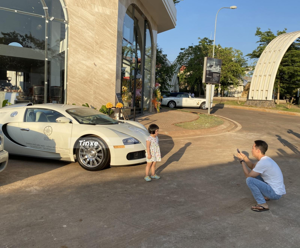 Một em nhỏ được người th&acirc;n chụp c&ugrave;ng với Bugatti Veyron