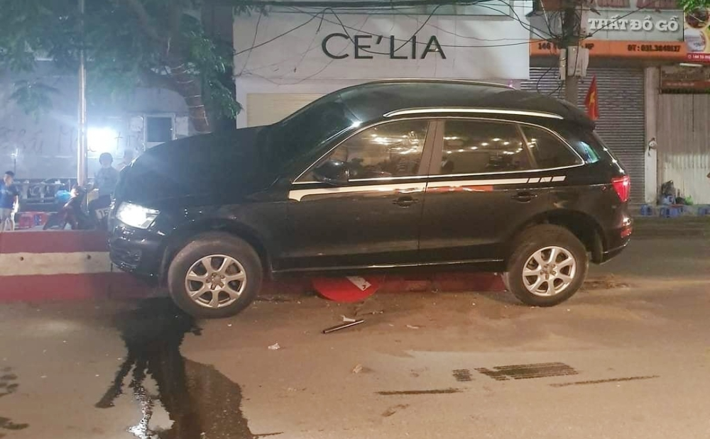 Chiếc xe Audi t&ocirc;ng v&agrave;o biển b&aacute;o rồi lao l&ecirc;n dải ph&acirc;n c&aacute;ch