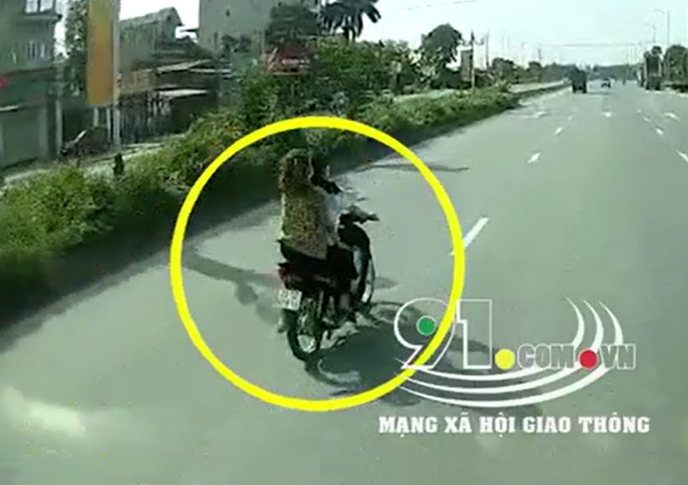 Hai cô gái không đội mũ bảo hiểm, đi xe máy trên đường trục chính của Khu công nghiệp Bắc Thăng Long