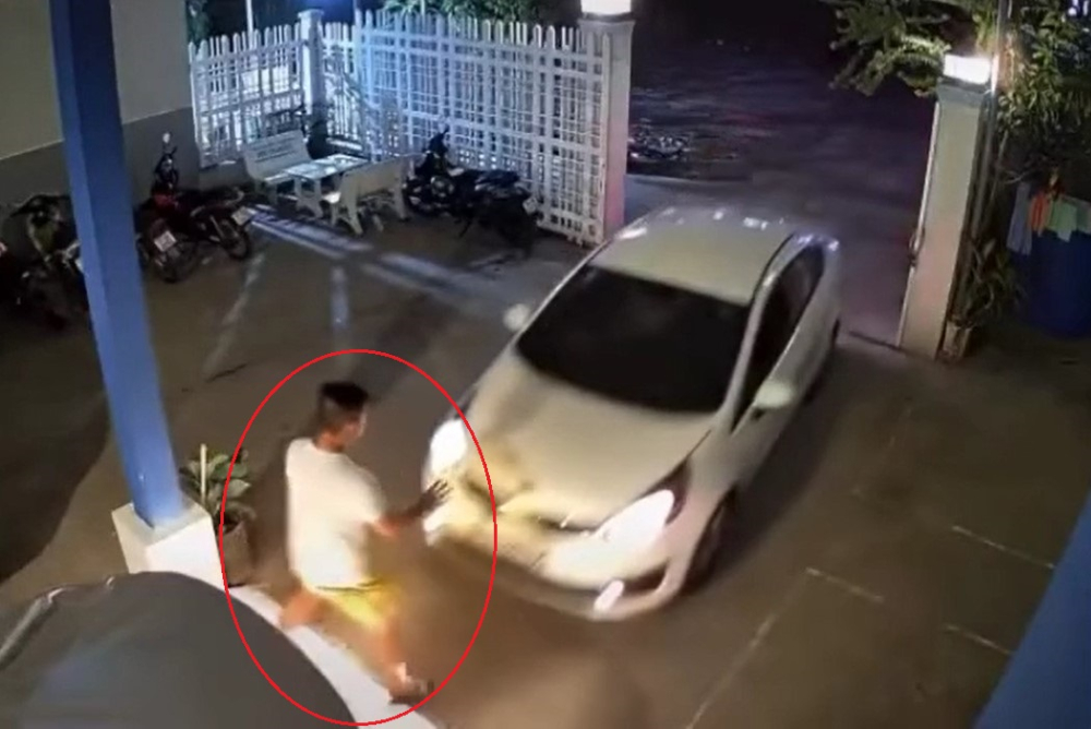 Chiếc ô tô Kia lao vọt về phía trước, tông trúng người đàn ông đang đứng hướng dẫn đỗ xe