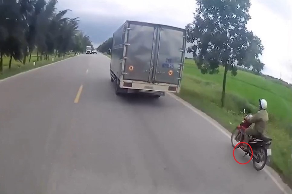 Người đi xe máy quên gạt chân chống lên