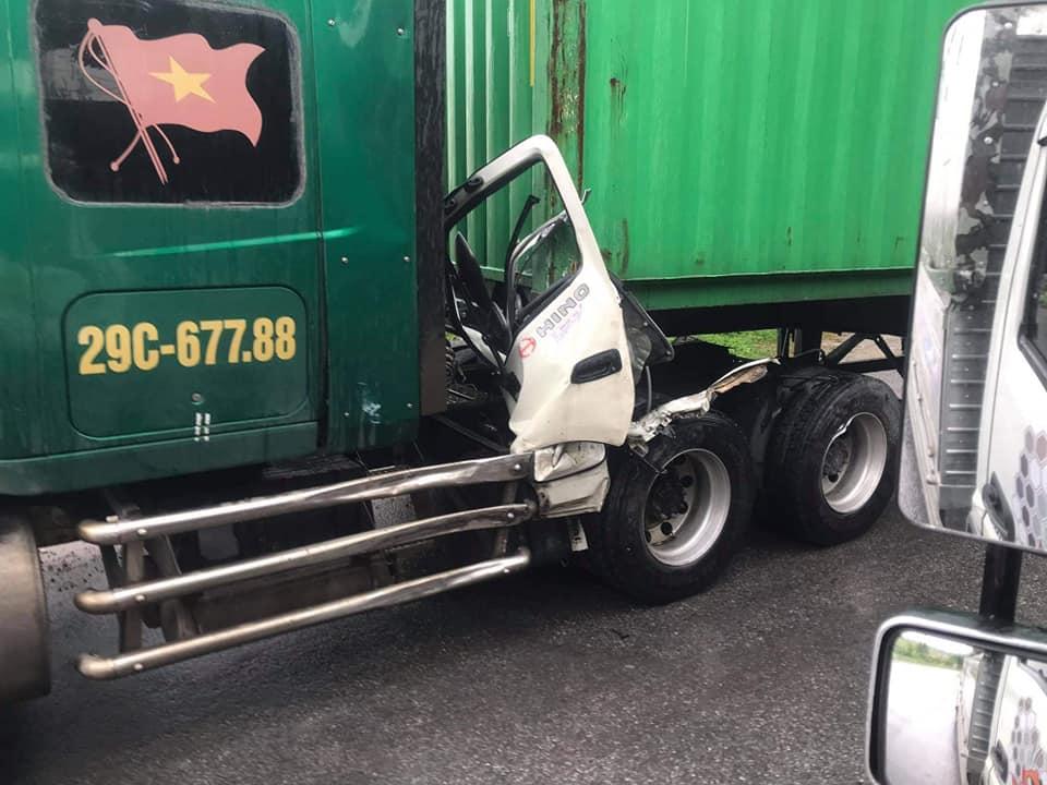 Cưa bên ghế lái của chiếc ô tô tải mắc kẹt trên xe container