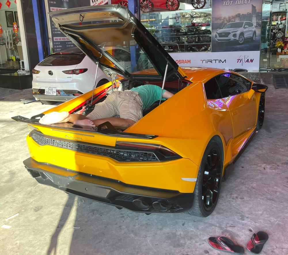 Một người khác nằm hẳn lên động cơ siêu xe Lamborghini Huracan để tìm các con số bí ẩn này