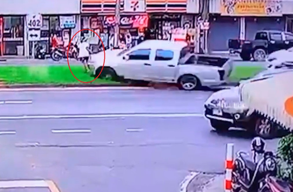 Người phụ nữ đi bộ nhanh chân bỏ chạy khi 2 chiếc ô tô lao về phía dải phân cách