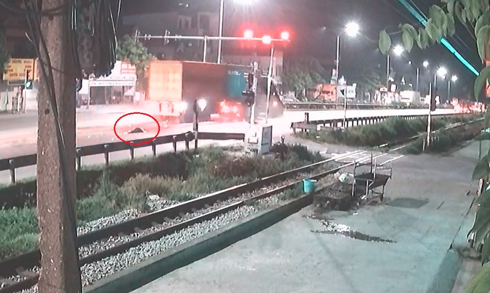 C&ocirc; g&aacute;i đi xe m&aacute;y nằm bất động tr&ecirc;n đường sau khi va chạm với xe container