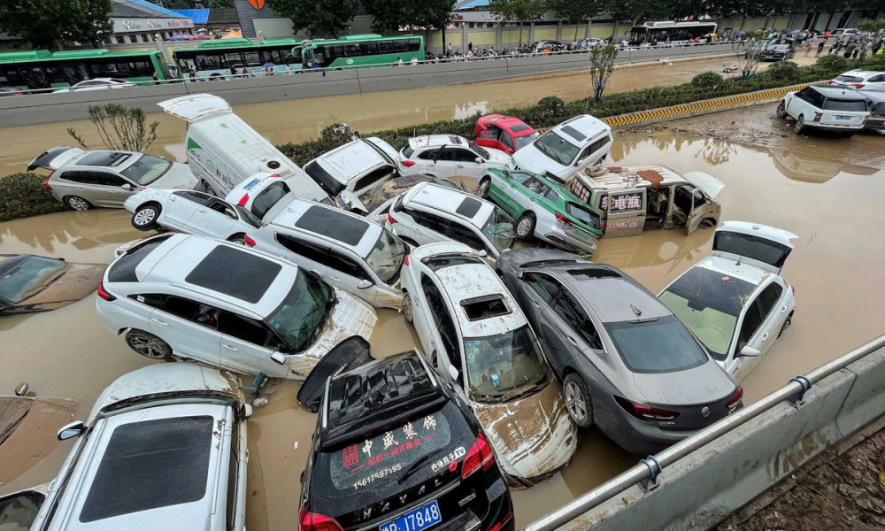 Những chiếc &ocirc; t&ocirc; bị nước lũ cuốn tr&ocirc;i v&agrave; dồn đống v&agrave;o nhau