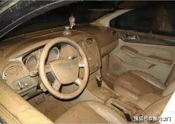 Một chiếc ô tô bị nước lũ tràn vào cả khoang lái và khi rút đi để lại đầy bùn đất