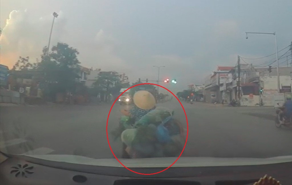 Người phụ nữ đi xe đạp điện chở rau sang đường bất cẩn