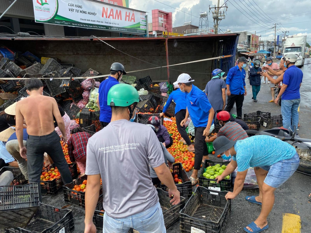 Người d&acirc;n hỗ trợ t&agrave;i xế sắp xếp lại c&aacute;c rau củ tươi trước khi c&oacute; xe tải kh&aacute;c đến chở h&agrave;ng