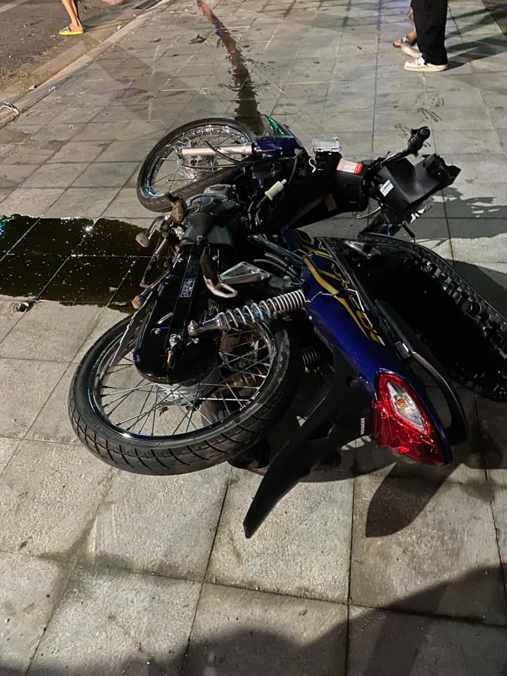 Chiếc xe m&aacute;y chở 2 nạn nh&acirc;n nằm tr&ecirc;n vỉa h&egrave; sau vụ tai nạn