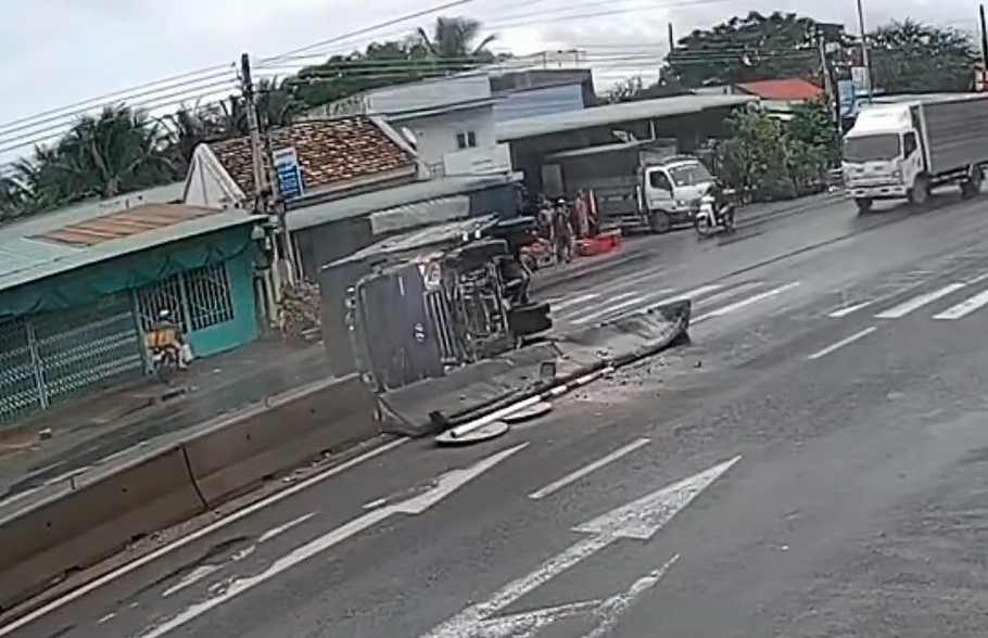 Chiếc ô tô tải lật ngang sau khi tông dải phân cách trên quốc lộ 1
