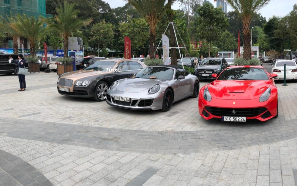 Từ tr&aacute;i sang l&agrave; Bentley Flying Spur V8 với 2 t&ocirc;ng m&agrave;u đẹp mắt, kế đến l&agrave; Porsche 911 Targa 4 GTS h&agrave;ng hiếm Việt Nam v&agrave; cuối c&ugrave;ng l&agrave; Ferrari F12 Berlinetta