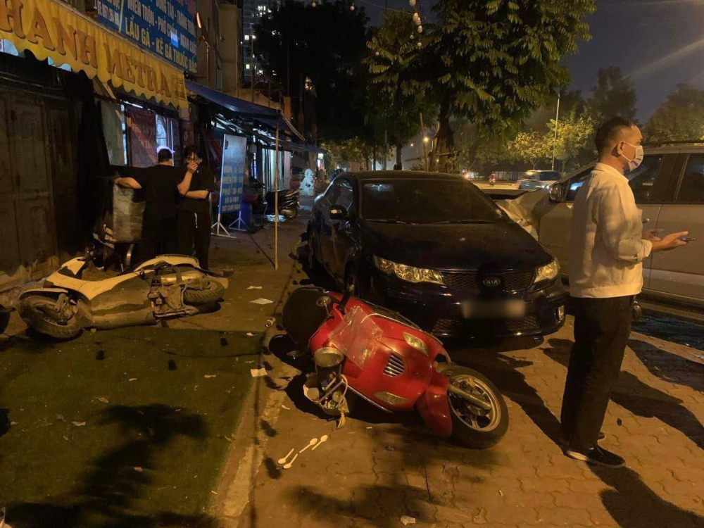 Nhiều xe máy nằm la liệt trên vỉa hè, ngoài ra còn có chiếc xe ô tô Kia Forte Koup Nhiều xe máy nằm la liệt trên vỉa hè, ngoài ra còn có chiếc xe ô tô Kia Forte Koup
