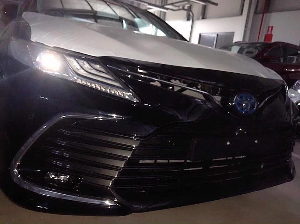 Toyota Camry 2022 đã được đưa về đại lý, trong ảnh chụp là một chiếc có logo Toyota màu xanh dương ám chỉ đây là phiên bản Hybrid.