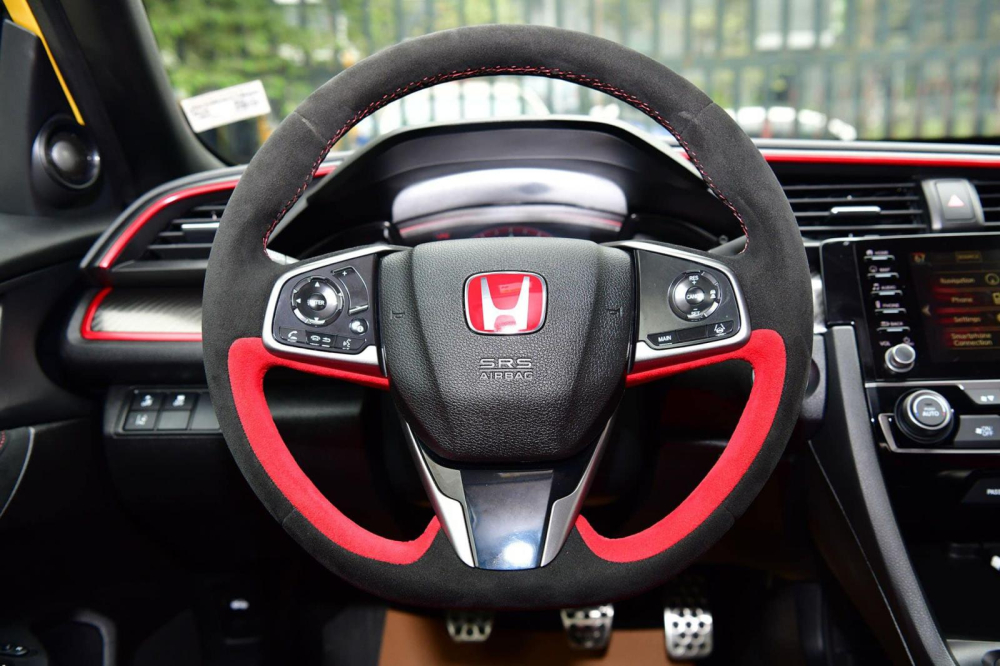 Vô-lăng xe bọc da Alcantara với 2 màu là đỏ và đen Vô-lăng xe bọc da Alcantara với 2 màu là đỏ và đen