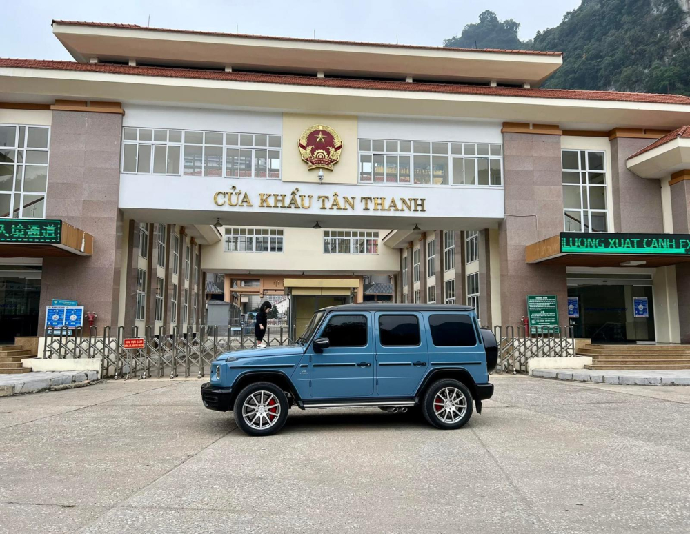 Chiếc xe Mercedes-AMG G63 màu xanh China dừng trước cửa khẩu Tân Thanh, cô con gái của Cường Đô-la còn đứng trên nắp capô xe để chơi
