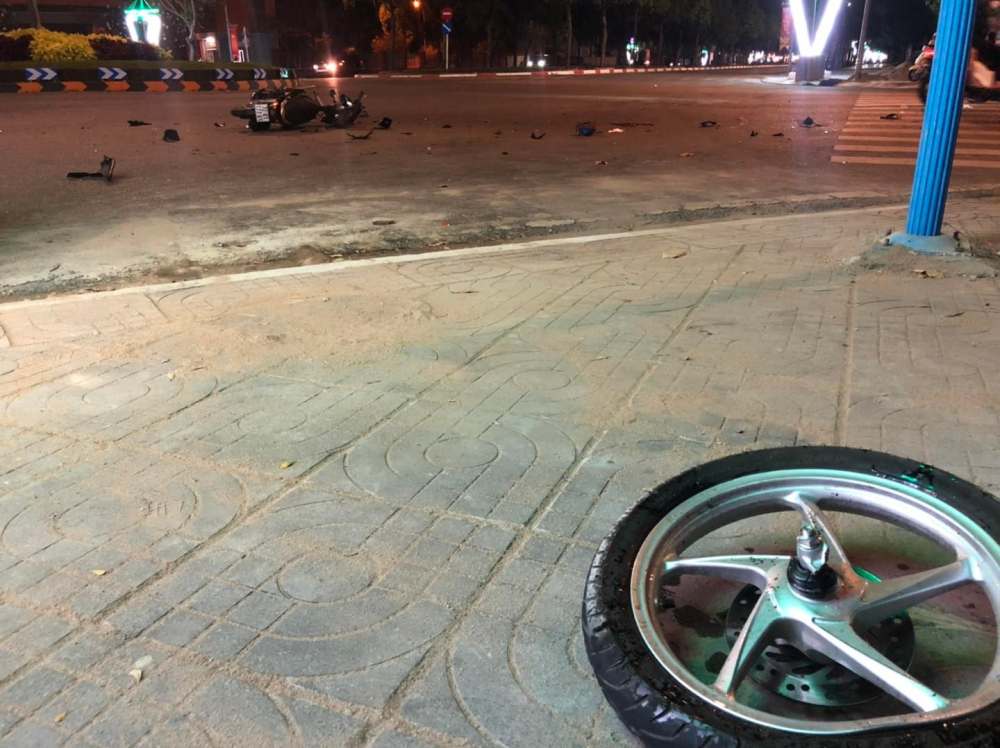 Bánh trước của chiếc xe máy văng lên vỉa hè