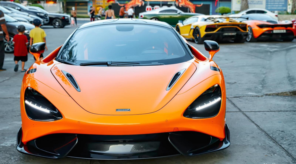 Cận cảnh McLaren 765LT và phía sau là gần chục siêu xe, xe siêu sang xếp hàng dài