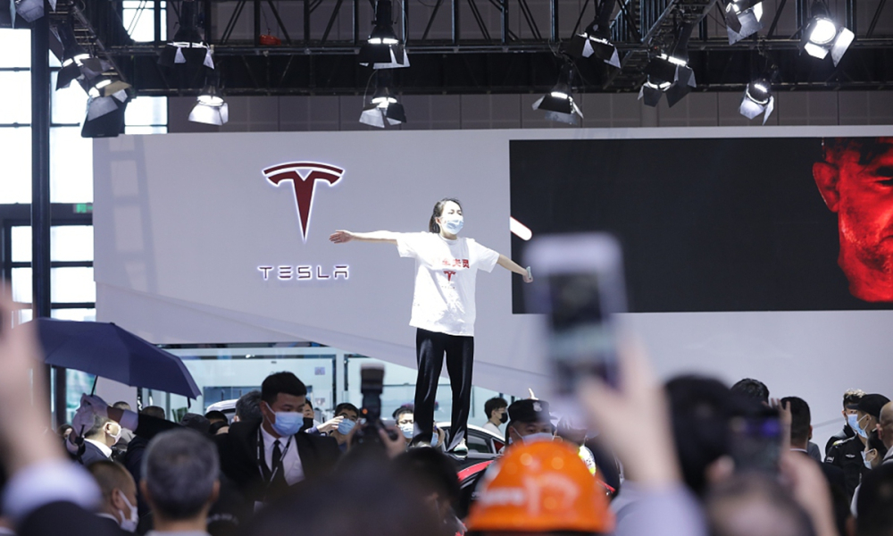 Người phụ nữ leo l&ecirc;n n&oacute;c chiếc &ocirc; t&ocirc; Tesla trong triển l&atilde;m &Ocirc; t&ocirc; Thượng Hải 2021